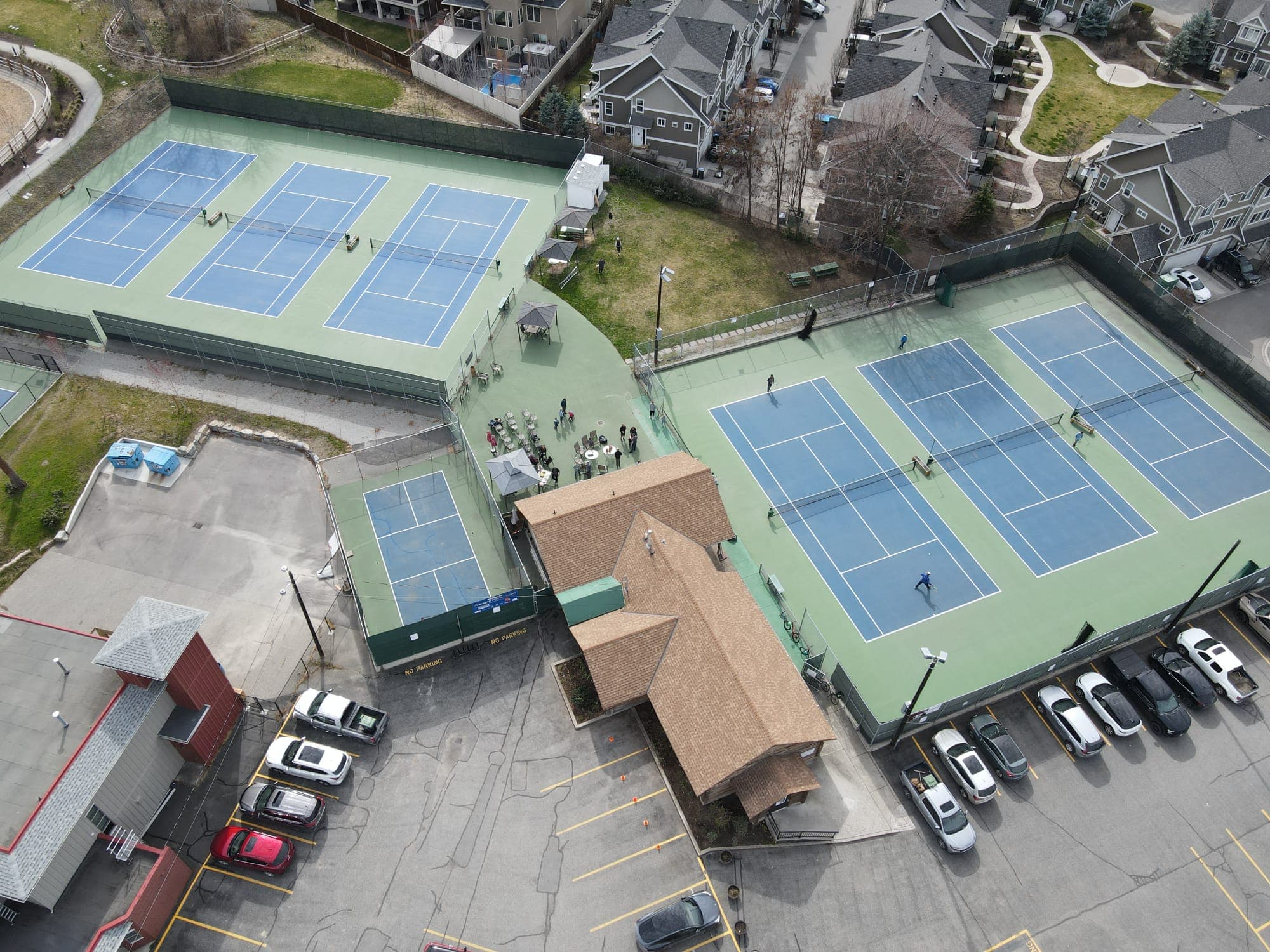 Players on the three courts beside the clubhouse, seen from above